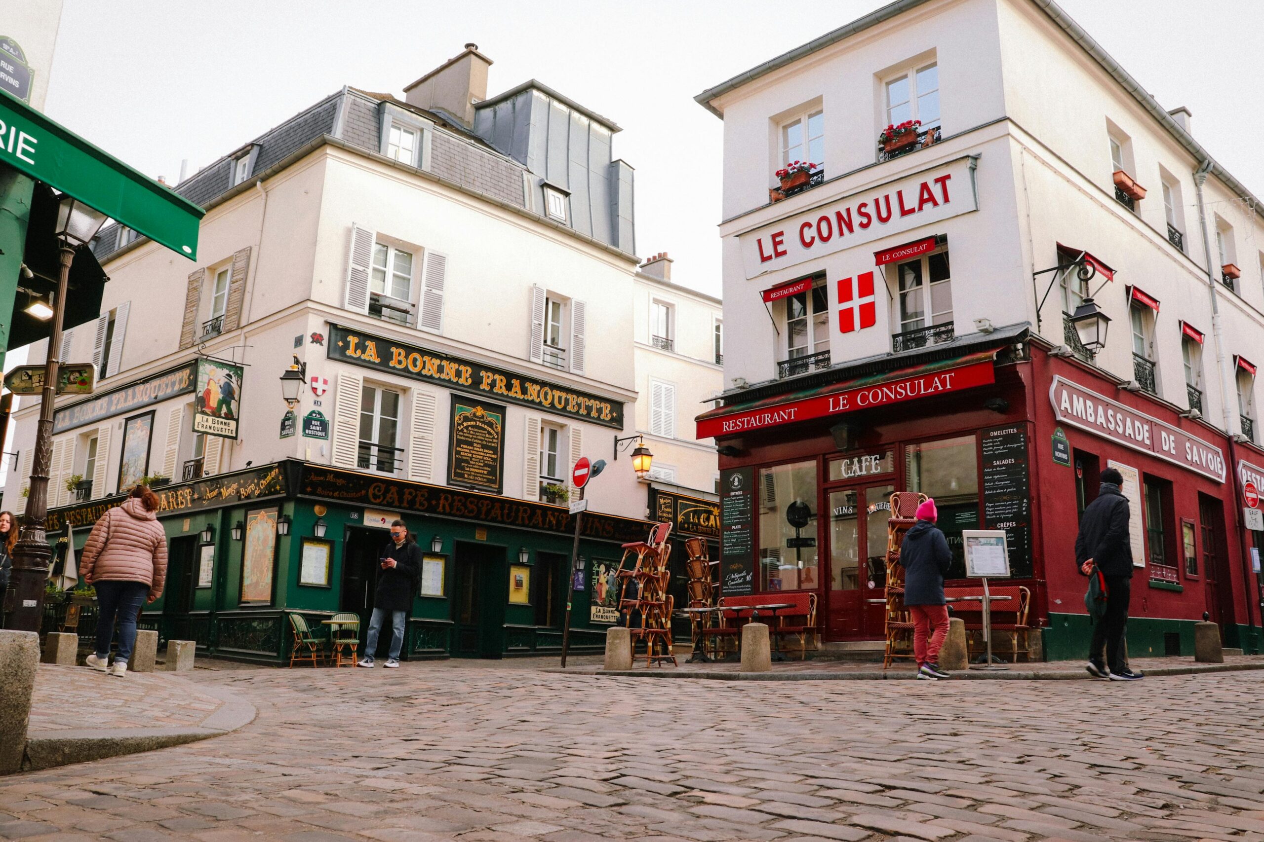 Charming street view of iconic Montmartre cafes in Paris, France.